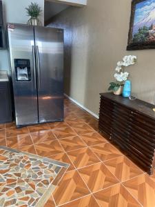 uma cozinha com um frigorífico de aço inoxidável e um piso de madeira em Large 4 bedroom home with gated parking em Puerto Peñasco