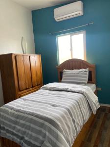 - une chambre bleue avec un lit et une fenêtre dans l'établissement Large 4 bedroom home with gated parking, à Puerto Peñasco
