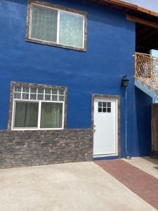 uma casa azul com uma porta branca e janelas em Large 4 bedroom home with gated parking em Puerto Peñasco
