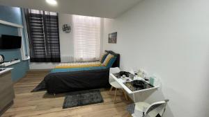 een kleine slaapkamer met een bed en een tafel bij Charmant studio de 25m², Douai in Douai