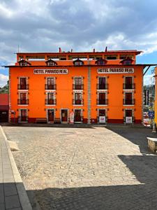 a large orange building withcriptions on it at Hotel Paraiso Real Plus in Mineral del Monte