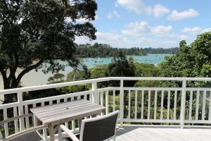 una mesa de madera y sillas en un balcón con vistas al río en Arcadia Lodge Russell en Russell