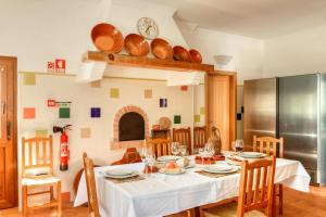 a kitchen and dining room with a table and chairs at Quinta dos Tesouros in São Brás de Alportel