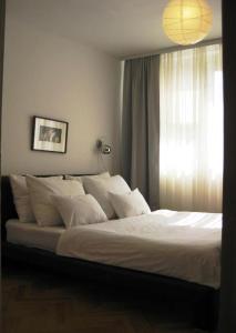 a bedroom with a large white bed with a window at Apartment Palas in Banja Luka