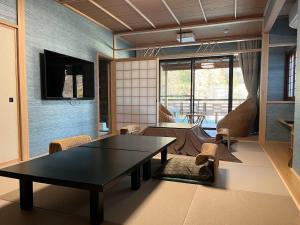 箱根仙景酒店的客厅里有一张黑色的桌子和椅子
