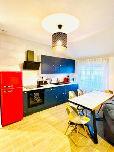a kitchen with a red refrigerator and a table at Merveilleux T2 en hypercentre in Châlons-en-Champagne