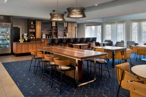 ハントバレーにあるCourtyard By Marriott Baltimore Hunt Valleyのテーブルと椅子のあるバーのあるレストラン