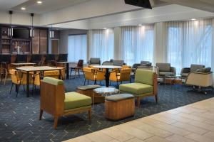 a waiting room with tables and chairs in a hospital at Courtyard By Marriott Baltimore Hunt Valley in Hunt Valley