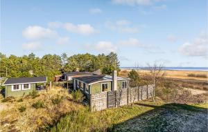 森讷比2 Bedroom Beautiful Home In Rømø的海边小山上的绿色房子