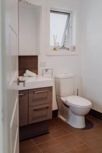 bagno con servizi igienici, lavandino e finestra di Apartment on James a Bicheno