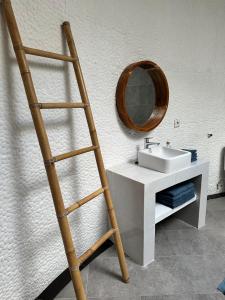a bathroom with a wooden ladder next to a sink at Asri Villas Bingin in Uluwatu