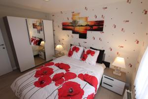 een slaapkamer met een bed met rode bloemen erop bij Skyline in Ieper