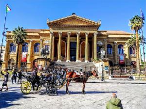 eine Pferdekutsche vor einem Gebäude in der Unterkunft Perla Diva Apartment in Palermo