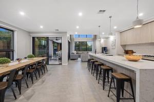 a kitchen with a long bar with stools at Villa Alessandro - Mornington Peninsula Luxury Accommodation in Tootgarook