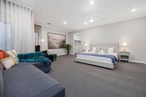 a bedroom with a bed and a couch at Villa Alessandro - Mornington Peninsula Luxury Accommodation in Tootgarook +31 photos