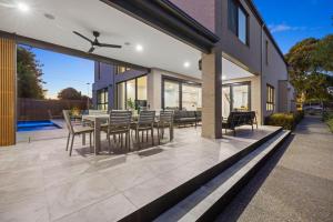 a patio with a table and chairs on a house at Villa Alessandro - Mornington Peninsula Luxury Accommodation in Tootgarook