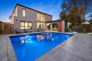 a swimming pool in front of a house at Villa Alessandro - Mornington Peninsula Luxury Accommodation in Tootgarook