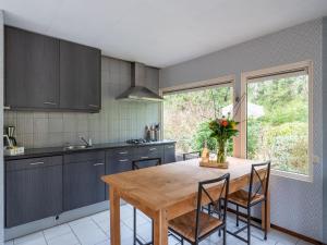 a kitchen with a wooden table and some chairs at Beautiful holiday home in Arendonk with garden in Arendonk