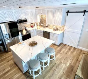 une cuisine avec un comptoir blanc et des tabourets dans l'établissement Tranquil Lake House, à Tallahassee