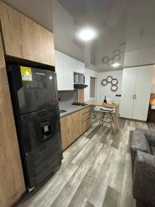 a kitchen with a black refrigerator and a table at Aparta estudio moderno in Envigado