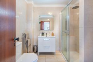 ein Bad mit einer Dusche, einem WC und einem Waschbecken in der Unterkunft AlgarSun - idealy situated holiday apartment with all modern comfort in Albufeira