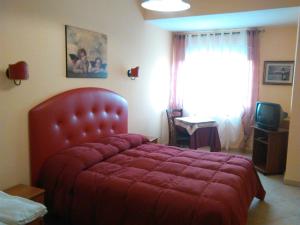 a bedroom with a red bed and a window at Mediterraneo Residence in Sciacca