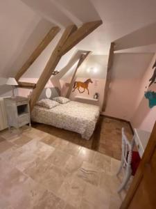 Schlafzimmer im Dachgeschoss mit einem Pferdebild an der Wand in der Unterkunft Gite La famille est dans les blés in Brinay