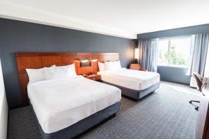 a hotel room with two beds and a window at Courtyard by Marriott Philadelphia Springfield in Springfield