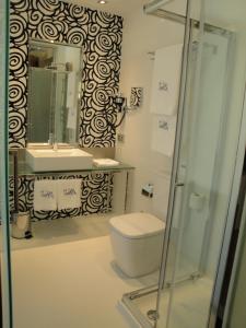 a bathroom with a toilet and a sink and a mirror at Hotel Vía Gótica in Burgos