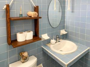 La salle de bains est pourvue de carrelage bleu, d'un lavabo et de toilettes. dans l'établissement Cómodo y bonito estudio en Cozumel, à Cozumel