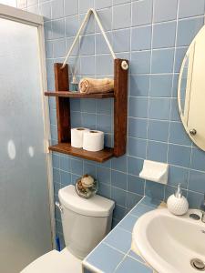 La salle de bains est pourvue de carrelage bleu, de toilettes et d'un lavabo. dans l'établissement Cómodo y bonito estudio en Cozumel, à Cozumel