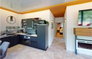 a large kitchen with blue cabinets and a fireplace at 2 Bedroom Gorgeous Apartment In Burgen in Burgen
