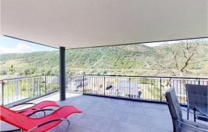 a balcony with red chairs and a view of a mountain at Stunning Apartment In Burgen With Kitchen in Burgen