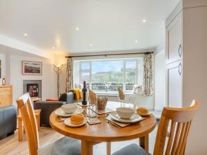 a kitchen and living room with a wooden table and chairs at The Burrow in Pateley Bridge