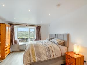 a bedroom with a bed and a window at The Burrow in Pateley Bridge