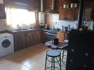 uma cozinha com um fogão e uma máquina de lavar roupa em La palmera em Trevelin
