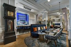 una hall con un divano blu e un bar di The Algonquin Hotel Times Square, Autograph Collection a New York