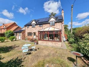 an exterior view of a brick house with a patio at Cobweb Cottage in Ludham