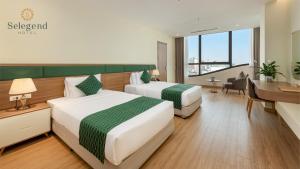 een hotelkamer met 2 bedden en een bureau bij Selegend Hotel Thái Bình in Thái Bình