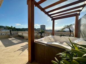 a bath tub sitting on top of a balcony at Cobertura de 3 quartos com hidromassagem e vista do por-do-sol in Guarujá
