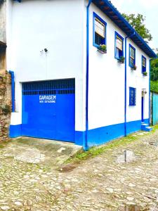 a blue and white building with a garage at Casa charmosa no Centro Histórico com garagem in Ouro Preto