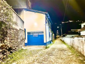 a blue and white door on a building at night at Casa charmosa no Centro Histórico com garagem in Ouro Preto