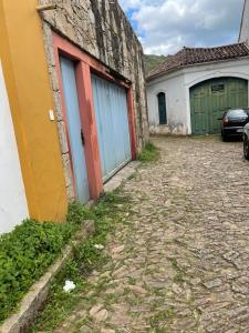 an alley with two doors and a car parked next to a building at Casa charmosa no Centro Histórico com garagem in Ouro Preto