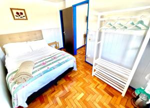 a bedroom with a bed and a wooden floor at Casa charmosa no Centro Histórico com garagem in Ouro Preto