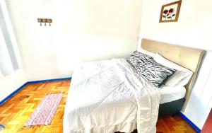 a bed with a white comforter in a room at Casa charmosa no Centro Histórico com garagem in Ouro Preto