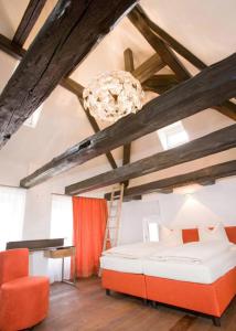レーゲンスブルクにあるホテル ミュンヘナー ホフ ウント ブラウアー トゥルムのベッド1台、はしご、シャンデリアが備わる客室です。