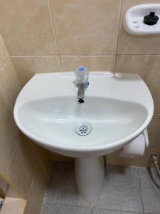 a white sink in a bathroom with aaucet at Hostal Venus - Nueva Imagen in Huacho