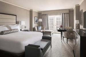 クレイトンにあるThe Ritz-Carlton, St. Louisの大きなベッドとデスクが備わるホテルルームです。