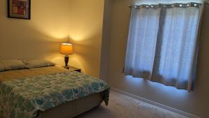 a bedroom with a bed and a window at The Warm Welcome Suite in Thorold