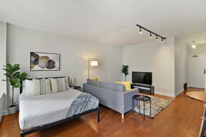 1 dormitorio con cama, sofá y TV en Chic and Roomy Studio Apt in the Near North Side - Chestnut 16D en Chicago